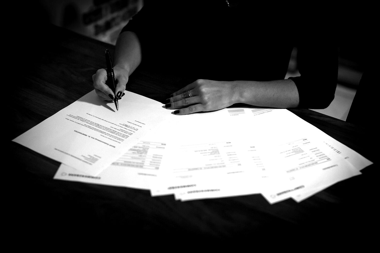 Manos firmando documentación societaria sobre una mesa.